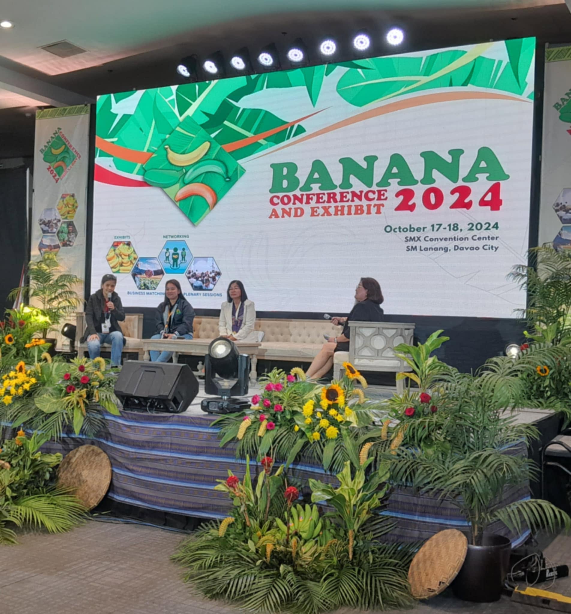 A panel discussion under way in front of a seated audience.